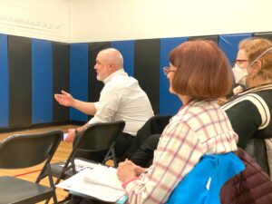 Resident asks question in front row audience at Troy Prep ARPA meeting